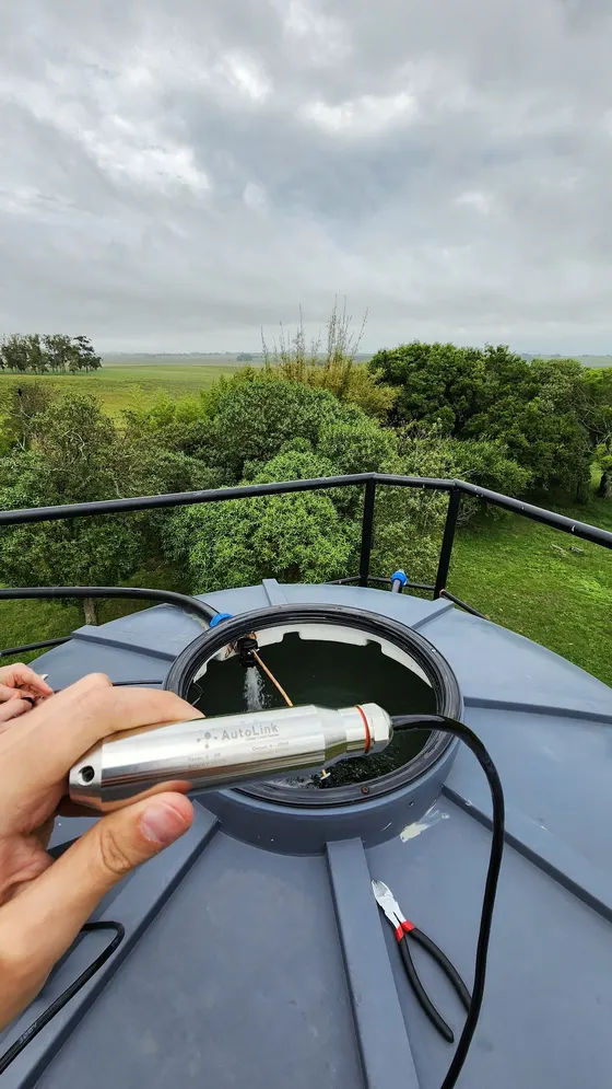 Sensor de nivel colocado en la boca de un tanque de agua en el campo